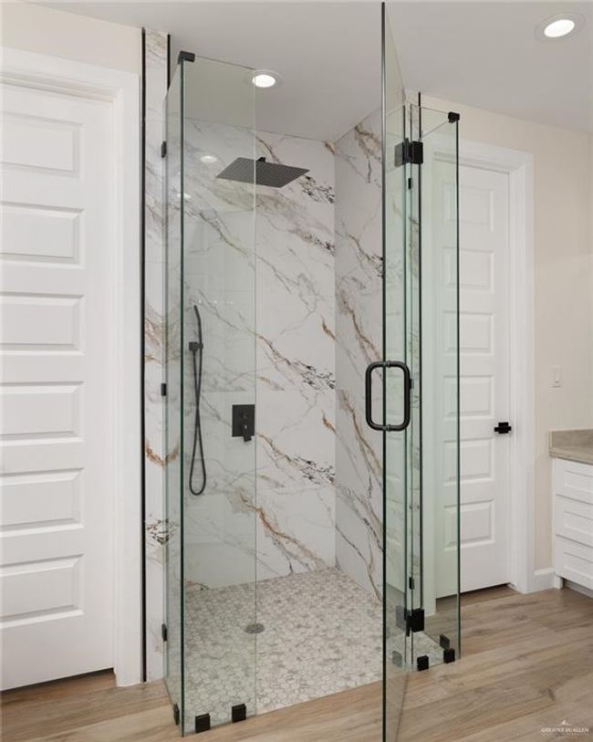 Bathroom with a marble finish shower, wood finished floors, vanity, and recessed lighting | Image 6