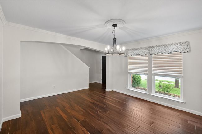 Formal dining area with a chandelier, crown molding, and dark wood-type tile flooring | Image 4