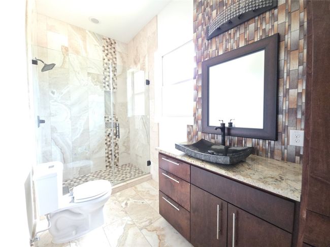Bathroom with a stall shower, vanity, toilet, and marble finish floors | Image 25