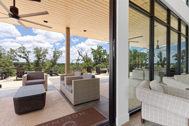 View of patio featuring a ceiling fan and outdoor lounge area | Image 37
