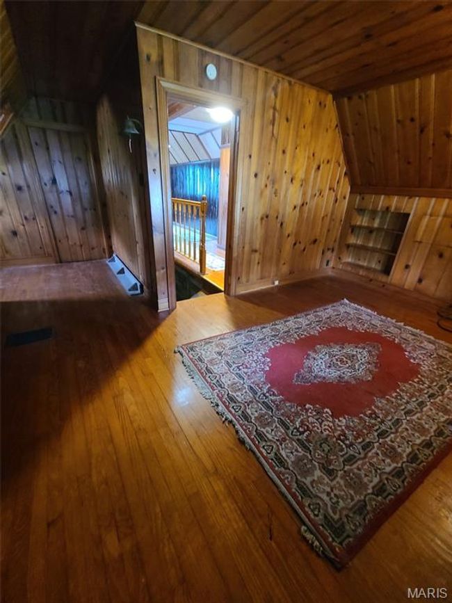 Additional living space featuring hardwood / wood-style flooring, wood walls, and wood ceiling | Image 19