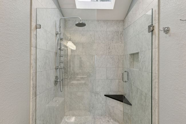 Bathroom with a stall shower, a skylight, and a textured wall | Image 22