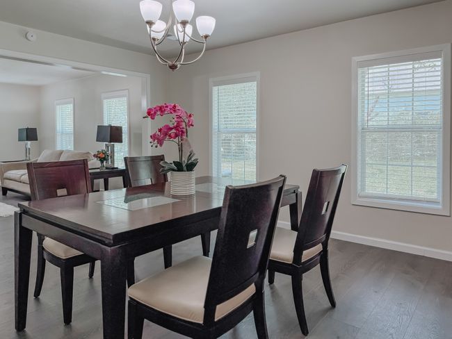 Dining room with a chandelier and wood finished floors | Image 12