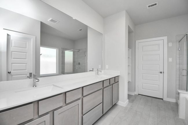 Elevate your daily routine at the elegant vanity, now equipped with double sinks, light countertops, modern hardware, and beautiful recessed lights. | Image 28