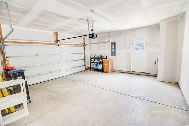Garage featuring a garage door opener and electric panel | Image 32