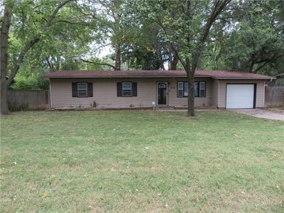 Ranch-style home featuring a garage and a front lawn | Image 1