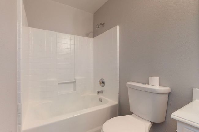 Bathroom with toilet, bathtub / shower combination, and vanity | Image 22
