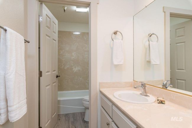 Full bathroom featuring vanity, wood finished floors, and washtub / shower combination | Image 13