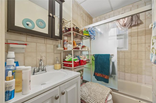 Bathroom featuring vanity, shower / bathtub combination, and backsplash | Image 30