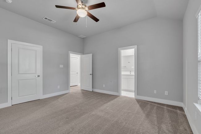 Unfurnished bedroom with carpet floors, baseboards, vaulted ceiling, and visible vents | Image 16