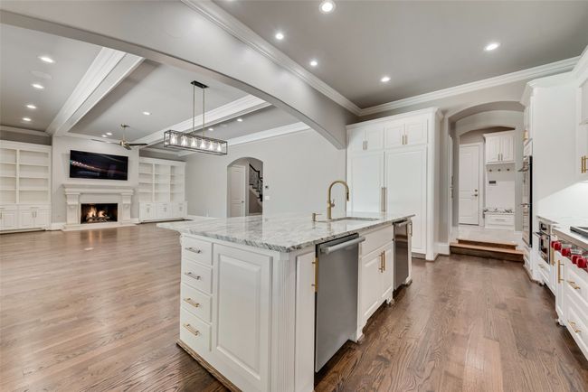 Kitchen featuring a ceiling fan, a sink, arched walkways, stainless steel appliances, and ornamental molding | Image 15