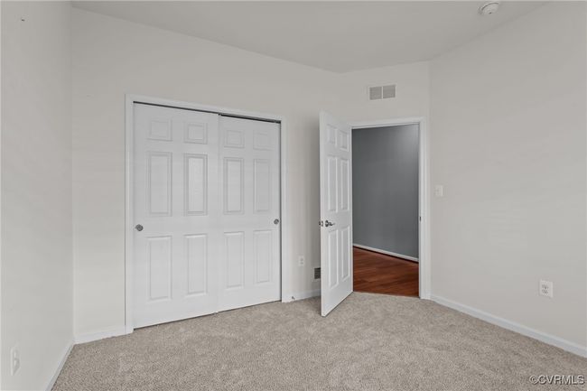 Unfurnished bedroom with carpet flooring and a closet | Image 27
