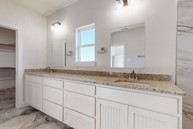 Full bathroom with a walk in closet, double vanity, visible vents, and a sink | Image 27