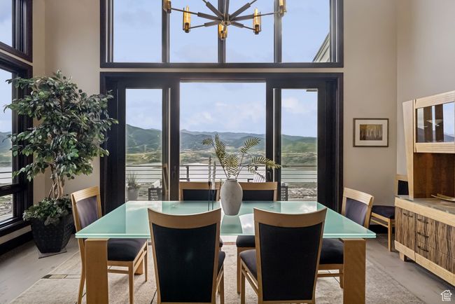 Dining area featuring a chandelier, a high ceiling, a mountain view, and wood finished floors | Image 25