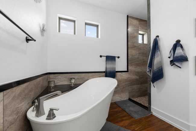 Full bathroom with a freestanding bath, tile walls, a walk in shower, and wood finished floors | Image 23
