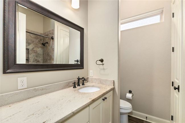 Guests will appreciate this clean and crisp full bathroom, featuring a granite-topped vanity, bronze finishes, and a convenient tub/shower combination. | Image 24