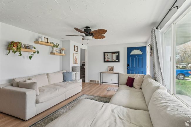 Living room featuring wood finished floors, visible vents, and a ceiling fan | Image 6