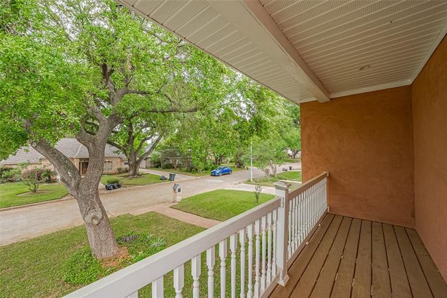 Enjoy your morning coffee or an evening breeze on this upper-level balcony. With a serene view of the neighborhood and leafy mature trees, it's the perfect spot for relaxing or catching up with neighbors. There are balconies/patio off of each master bedroom. | Image 32
