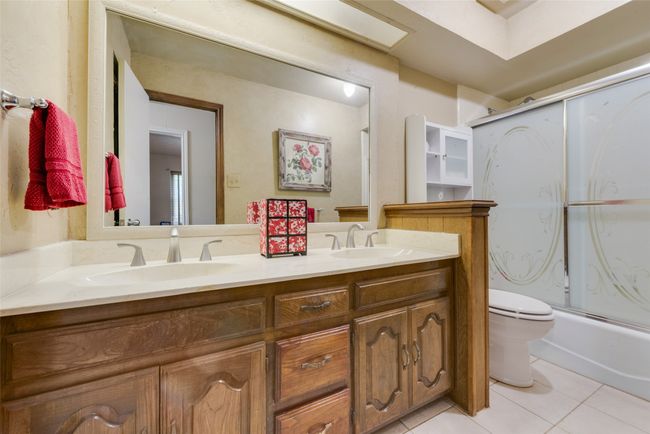Bathroom featuring tile patterned floors, an enclosed shower, toilet, and double vanity | Image 27