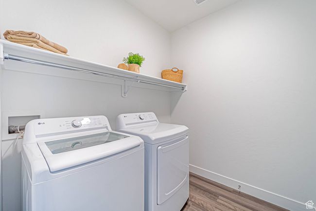 Laundry area with visible vents, baseboards, laundry area, light wood finished floors, and washing machine and clothes dryer | Image 15