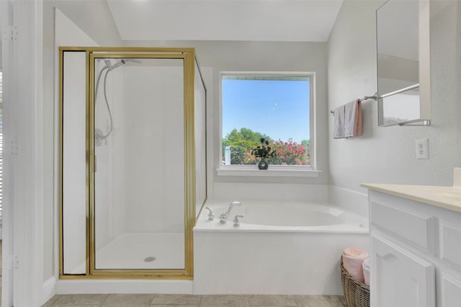 Full bathroom with vanity, a stall shower, a garden tub, and tile patterned floors | Image 32