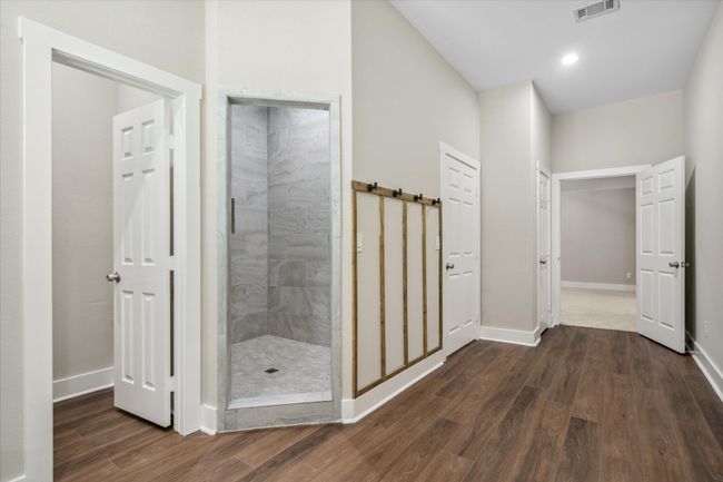 Bathroom with a tile shower, wood finished floors, and baseboards | Image 16