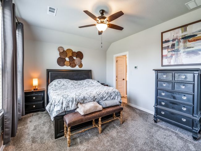 Carpeted bedroom featuring vaulted ceiling, visible vents, baseboards, and ceiling fan | Image 20