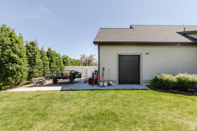 Rear view of property with stucco siding, a shingled roof, and a patio area | Image 47