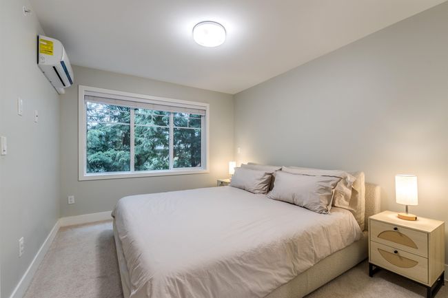 Bedroom featuring a wall unit AC, light carpet, and baseboards | Image 14