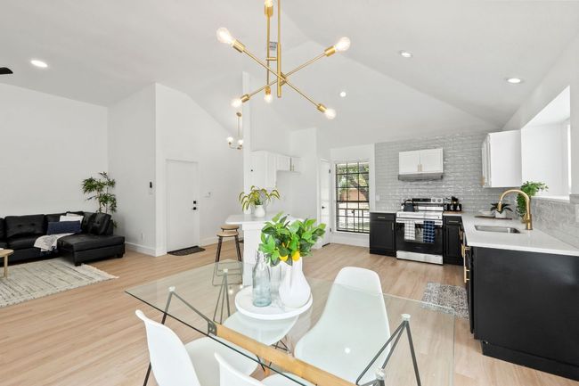Dining room featuring lofted ceiling, light an inviting chandelier | Image 11
