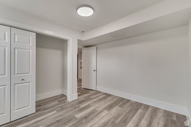 Unfurnished bedroom with light wood-style flooring, visible vents, baseboards, and a closet | Image 23