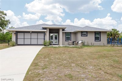 View of front facade with a garage and a front yard | Image 1