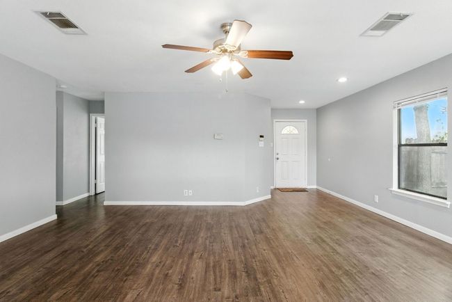 Living room taken from dining area. Front door is in right background. Open door to bedroom #3 is in the left background. | Image 13