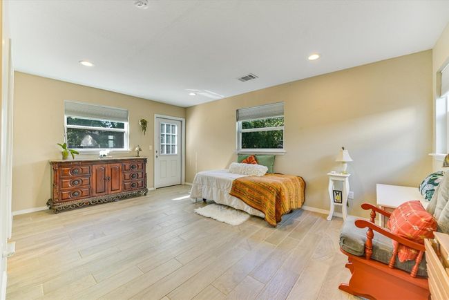 The spacious primary bedroom offers a calm retreat with backyard access and two separate closets for extra storage and organization | Image 11