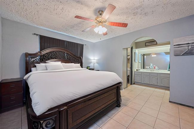 Adjacent view of primary bedroom with tile flooring. | Image 13