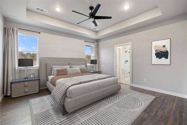 Bedroom featuring a tray ceiling, wood finished floors, baseboards, recessed lighting, and connected bathroom | Image 30