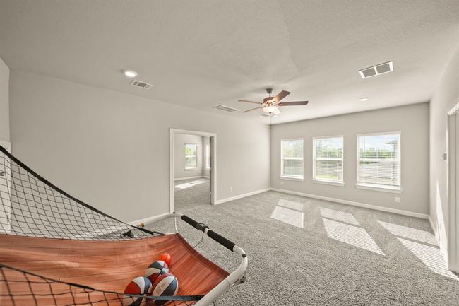 Spacious upstairs game room with plush carpeting and abundant natural light — perfect for a play area, home theater, or second living space. | Image 24
