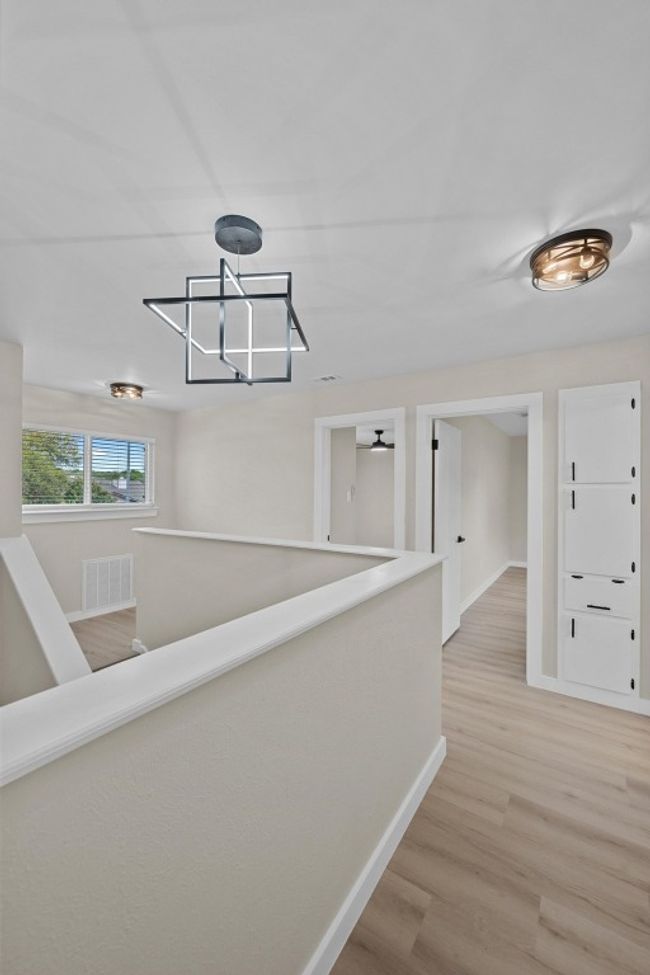 Corridor featuring light wood-type flooring, baseboards, and visible vents | Image 15