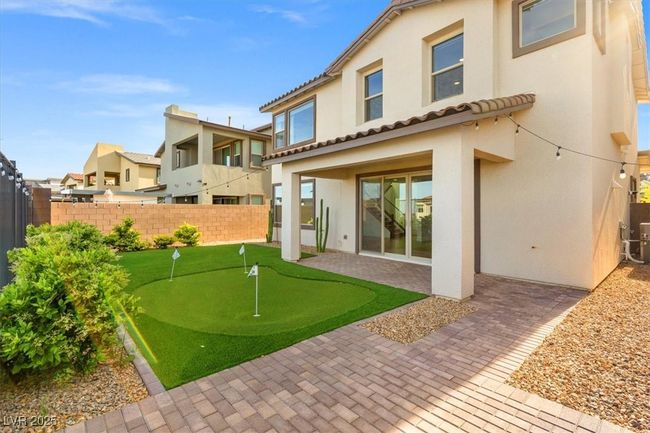 Rear view of property with stucco siding, fence, a patio area, and a tile roof | Image 49