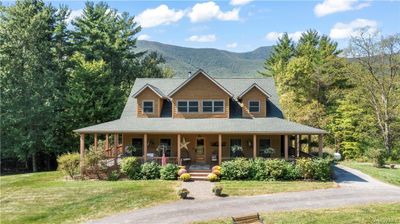 Farmhouse with a mountain view, a front lawn, and covered porch | Image 2