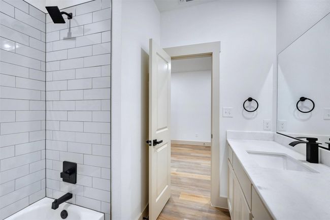 Full bathroom featuring bathing tub / shower combination, baseboards, vanity, and wood finished floors | Image 11