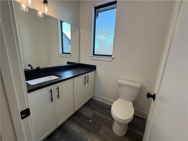 Bathroom with baseboards, toilet, vanity, and wood finished floors | Image 34