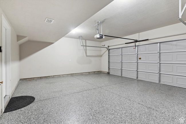 Garage featuring a garage door opener and baseboards | Image 29