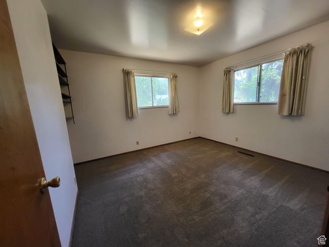 Spare room featuring healthy amount of natural light and dark carpet | Image 9