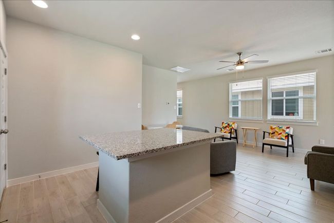 Kitchen featuring light wood-style flooring and an island/breakfast bar. | Image 12