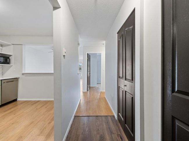 Hall featuring baseboards, wood finished floors, and a textured ceiling | Image 15
