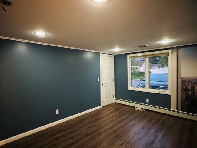 Bedroom featuring dark wood-style flooring, a baseboard heating unit, ornamental molding, and recessed lighting | Image 7