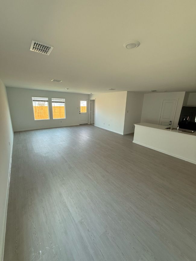 Unfurnished room featuring wood finished floors, baseboards, and a sink | Image 4
