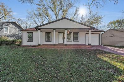 View of front facade featuring a front lawn, a garage, and a porch | Image 2