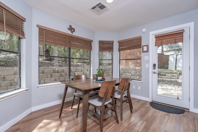 Dining space with baseboards, wood finished floors, and visible vents | Image 12